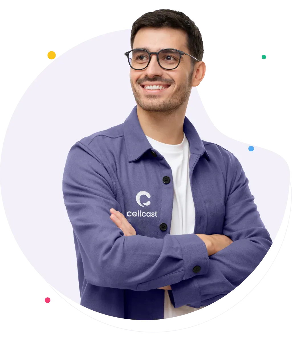 A smiling Cellcast team member in a denim shirt, arms folded